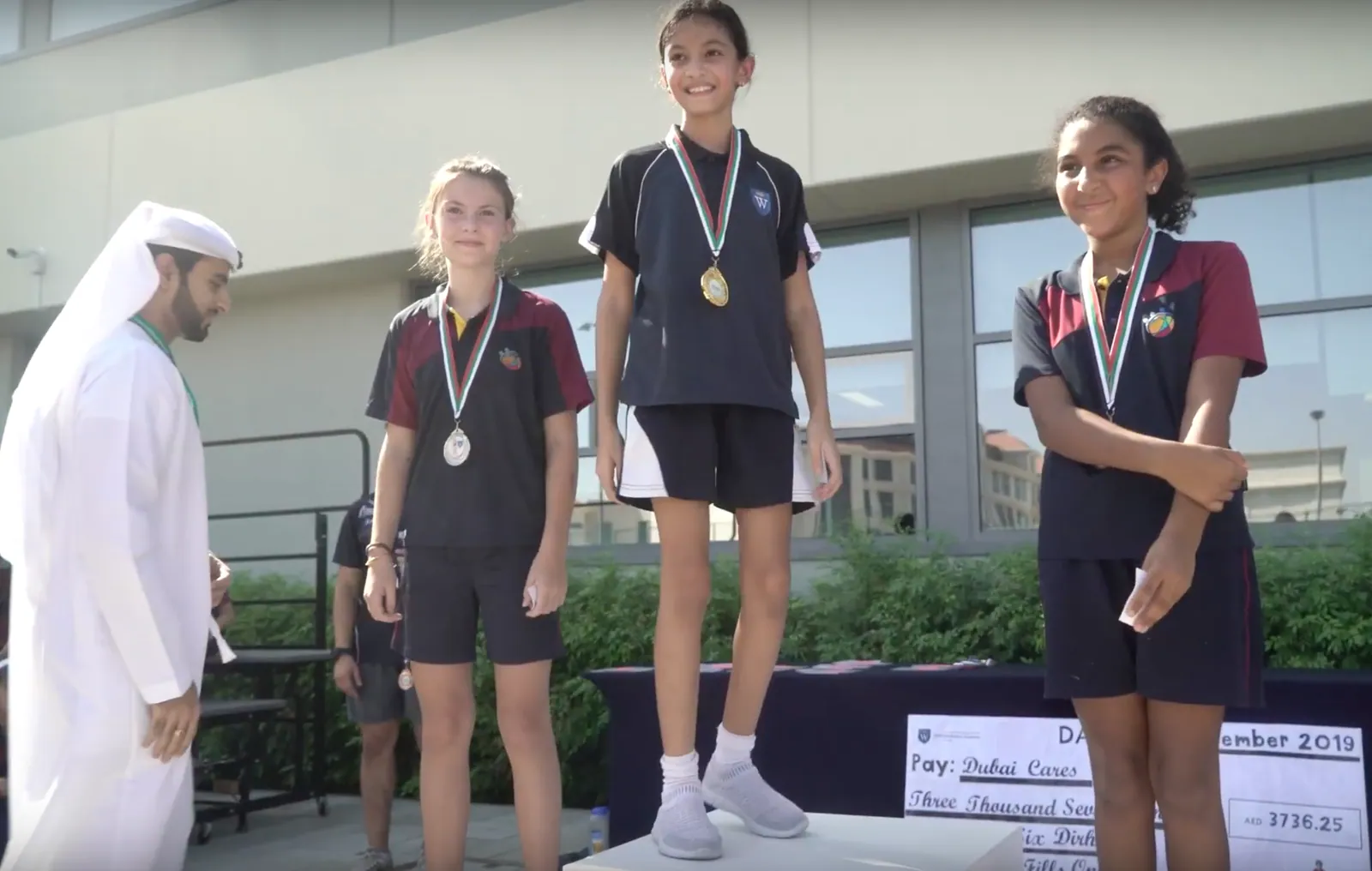 Students collect their medals on the dais.